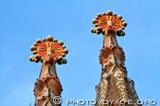 Les pinacles qui couronnent les tours des apôtres Jacques et Bartolomé 
sont recouverts de trencadis colorés et représentent les attributs 
des évêques (mitre, croix, crosse et anneau) - façade de la 
Passion de la Sagrada Familia