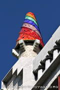 Une des cheminées du Palais Güell visible depuis la rue a la forme 
d'un cône décoré de trencadis colorés disposés 
en bandes spiralées.