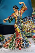 Statuette de danseuse de flamenco recouverte de trencadis dans la vitrine d'une boutique de souvenirs.
