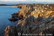 Vue de la côte déchiquetée de la pointe de Pen Hir en direction de l'anse et la plage de Pen Hat. Les rayons du soleil couchant mettent en valeur le relief et la couleur des rochers de Beg Penn Hir (nom breton). Presqu'île de Crozon dans le Finistère.