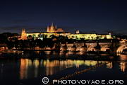 Pont Charles et Château de Prague éclairés de nuit se reflétant 
dans la Vltava