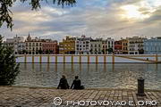 Couple profitant du coucher de soleil sur le Guadalquivir face aux maisons de 
la calle Betis alignées sur la rive de Triana.