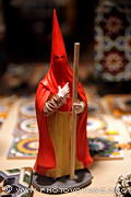 La tenue de pénitent se compose d'une tunique serrée à la 
taille par une cordelette, d'une cape et d'une cagoule pointue. La couleur de 
ces trois pièces peut différer ainsi que le cierge qu'il tient à 
la main.