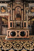 Autel de l'arrière-choeur de la cathédrale de Séville. Dans les églises 
espagnoles, le choeur est un espace fermé qui occupe le centre de la nef. 
Ce bloc massif bouche la perspective mais ses murs extérieurs sont richement 
décorés de blocs de marbre rose et noir, de bas reliefs et de peintures.