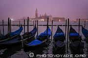 Lever du jour sur les gondoles de Venise amarrées devant le molo, le quai servant 
d'embarcadère aux nombreuses gondoles et vaporetto.
