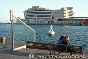 Amoureux assis sur un banc de la Rambla de Mar face au World Trade Center et au Moll de Barcelona - Port Vell