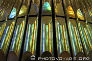 Gros plan sur les tuyaux des orgues de la Sagrada Familia dont le métal 
reflète les vitraux de l'abside.