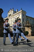 trois gardes en uniforme marchant au pas lors de la relève à la 
porte du château